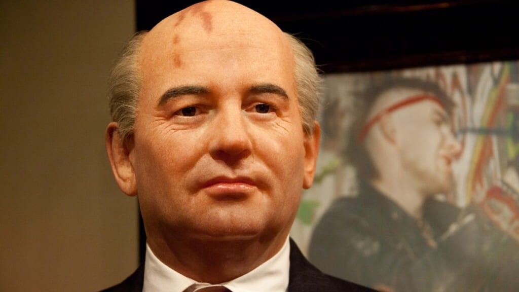Mikhail Gorbachev in front of a poster of a punk