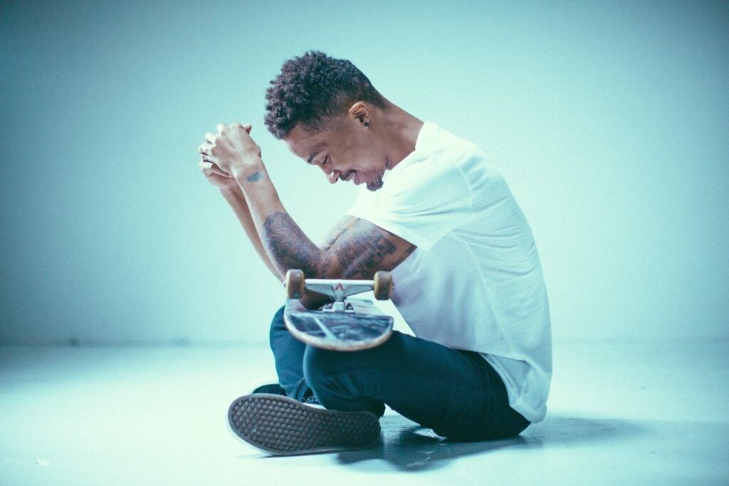 man-sitting-skateboard-thinking-purpose