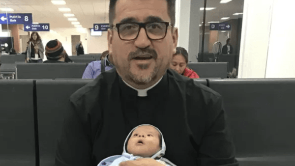 priest holding a baby