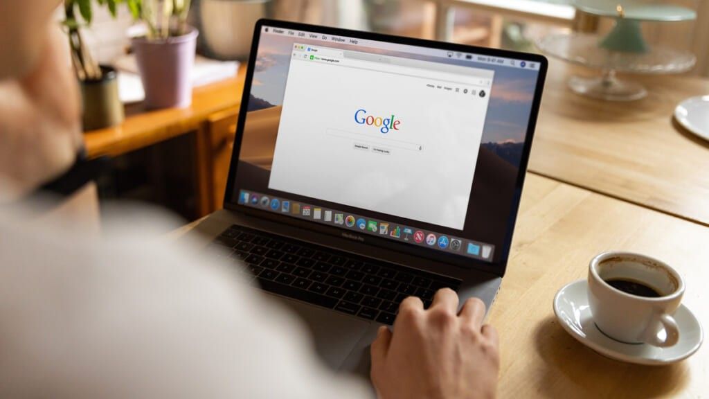 Man looking at Google on laptop