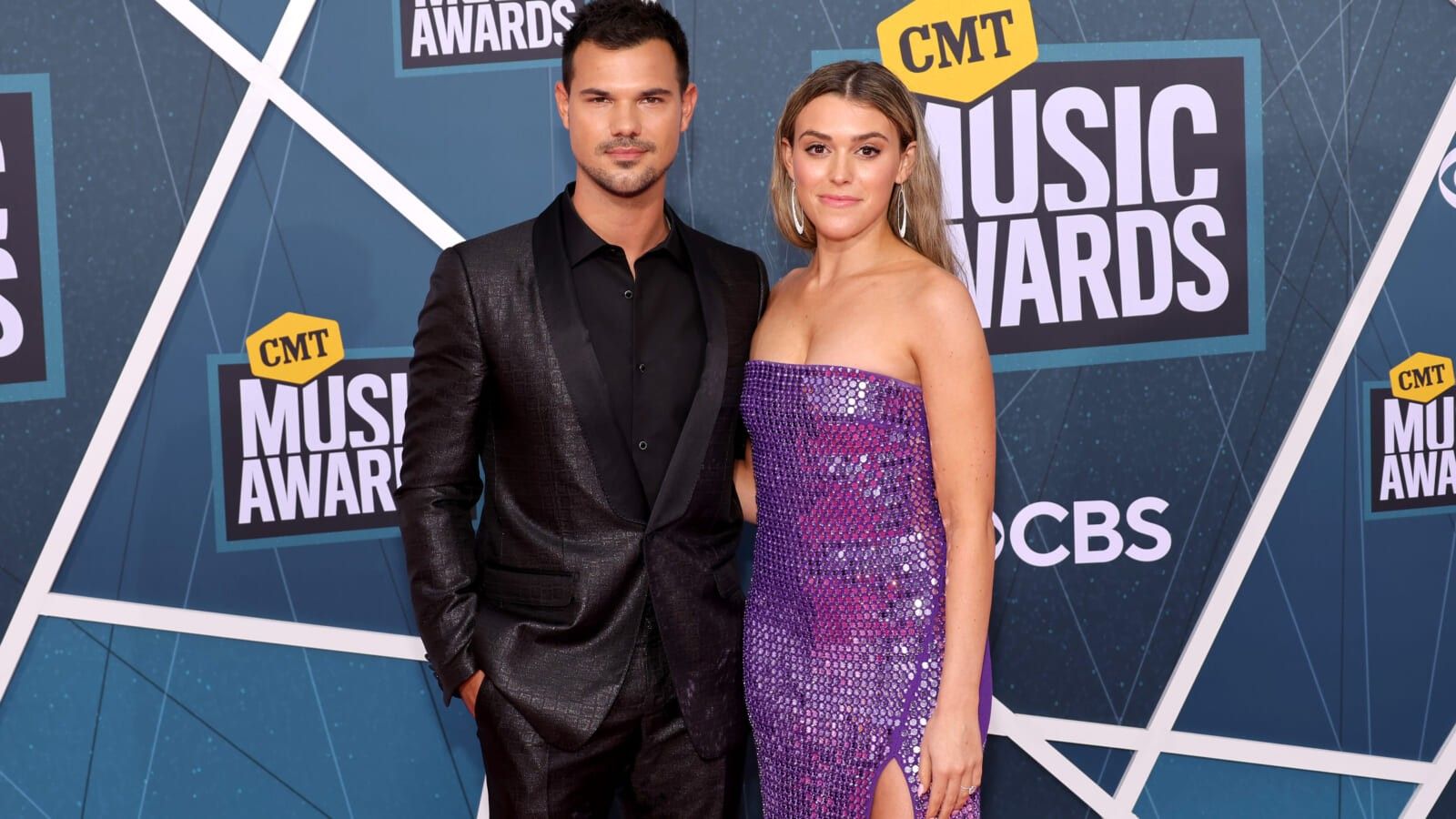man wearing a black suit and a woman wearing a sparkly purple full length dress