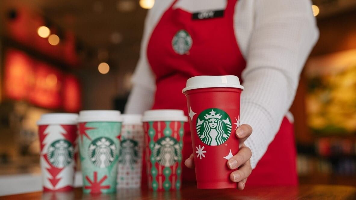 woman holding a red starbucks cup