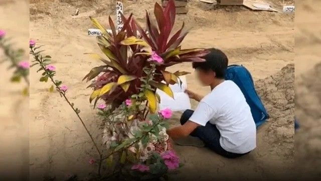 boy sitting near a grave