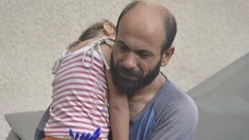 tired man carrying a sleeping child