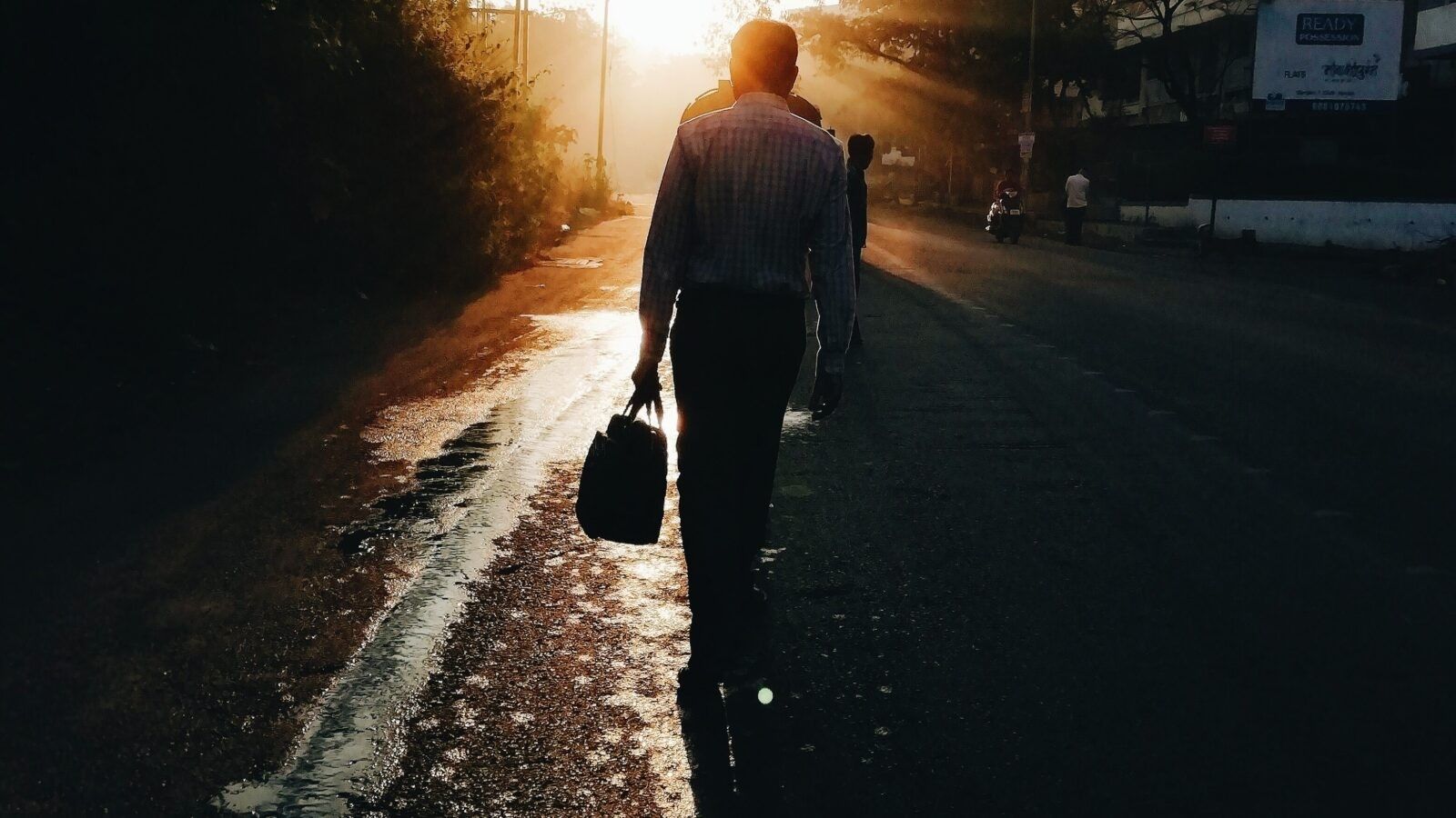 man holding a bag walking on the street