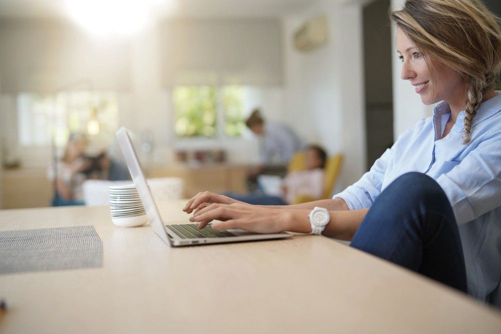 blonde-woman-smiling-working-laptop