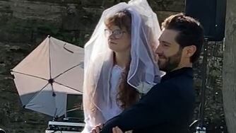 groom carrying a woman in a wedding dress