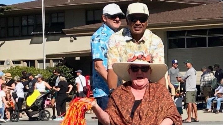 three people wearing sunglasses and caps outside