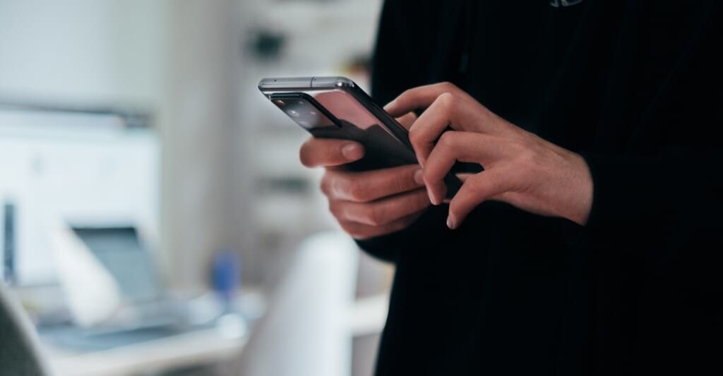 person looks at their smart phone