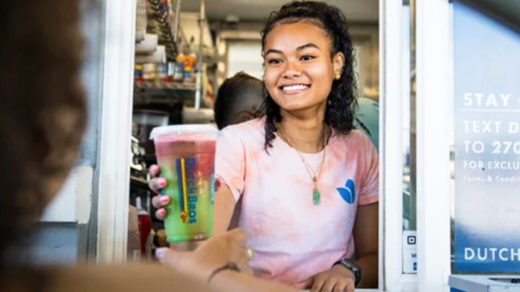 Dutch Bros. drive-thru employee gives a driver a drink