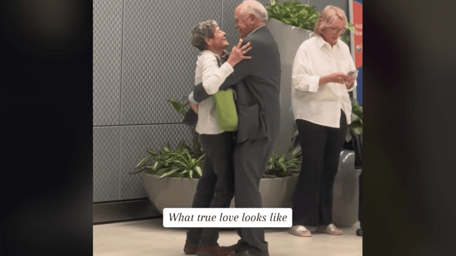 man and woman embracing in airport