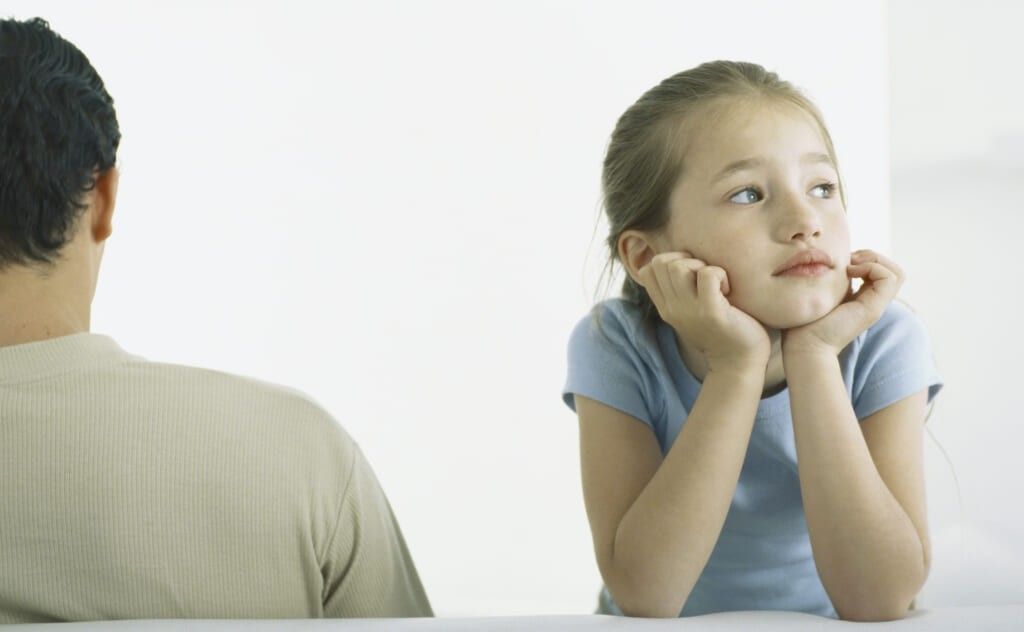 Girl holding head, leaning on elbows next to man, rear view