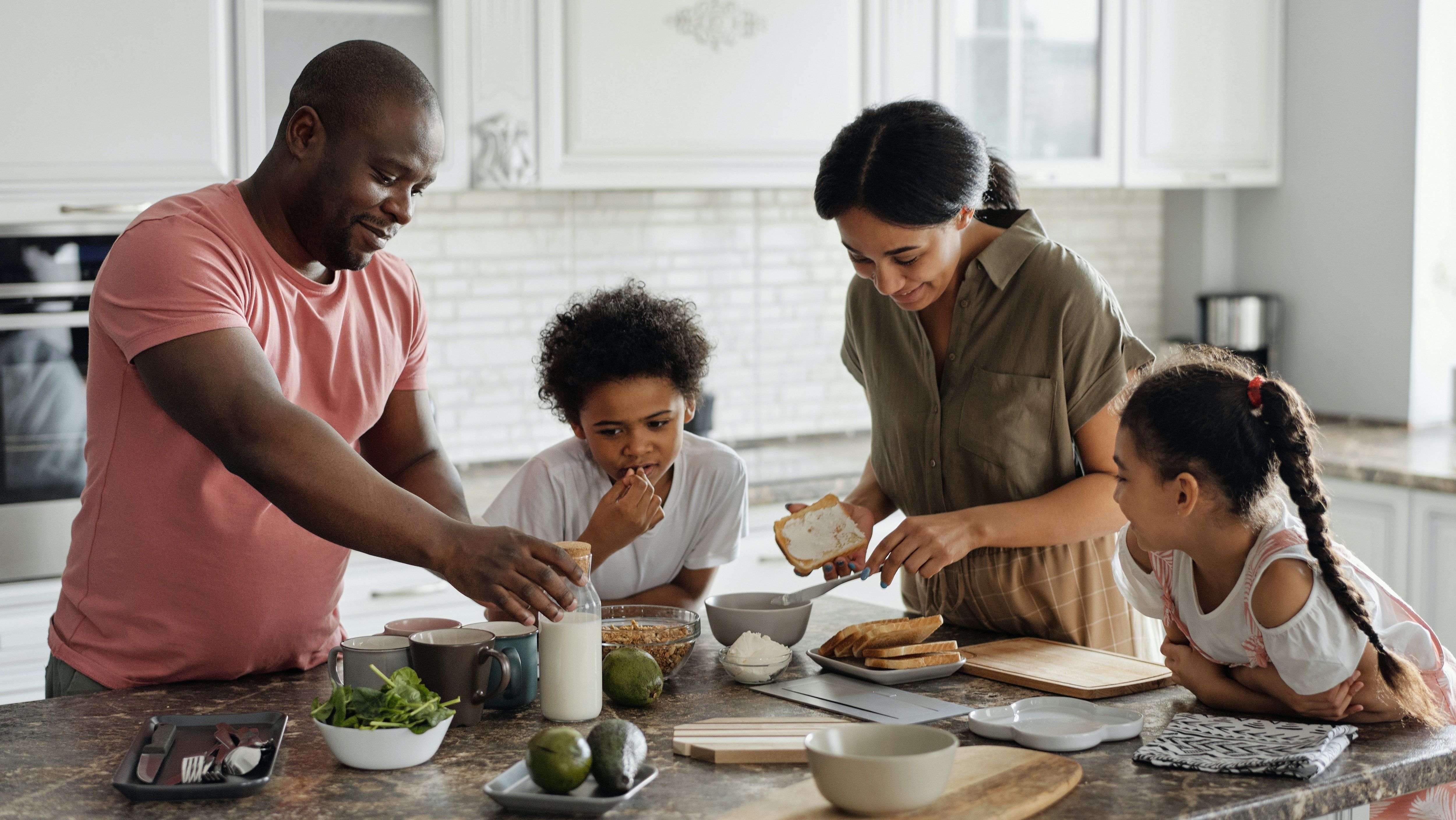 a father, mother and their two kids cooking in the kitchen