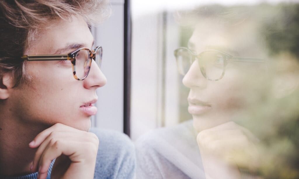 young man looks out the window