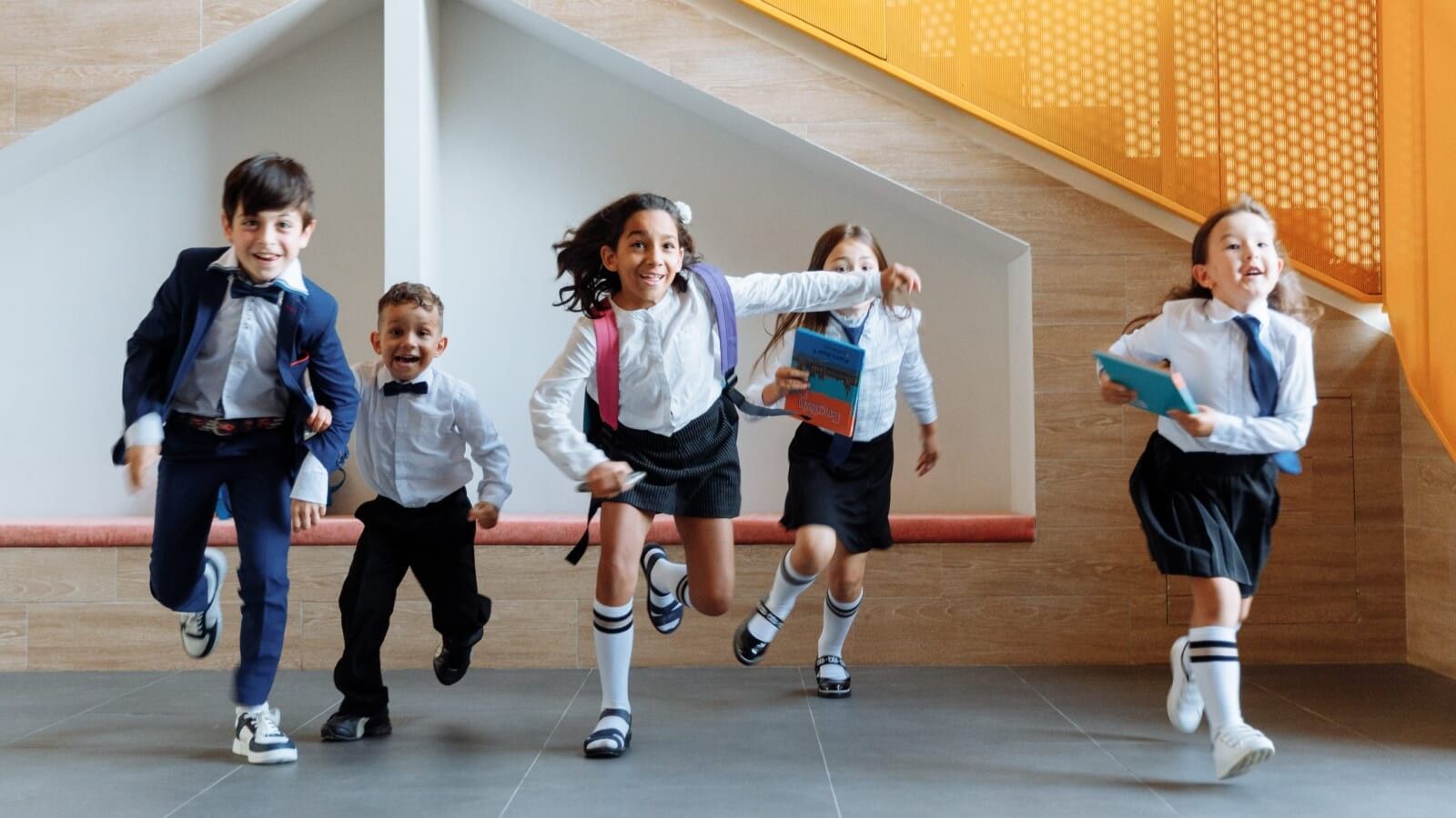 children in school uniforms running
