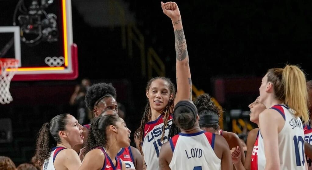 Brittney Griner with her team all wearing their uniforms and cheering.