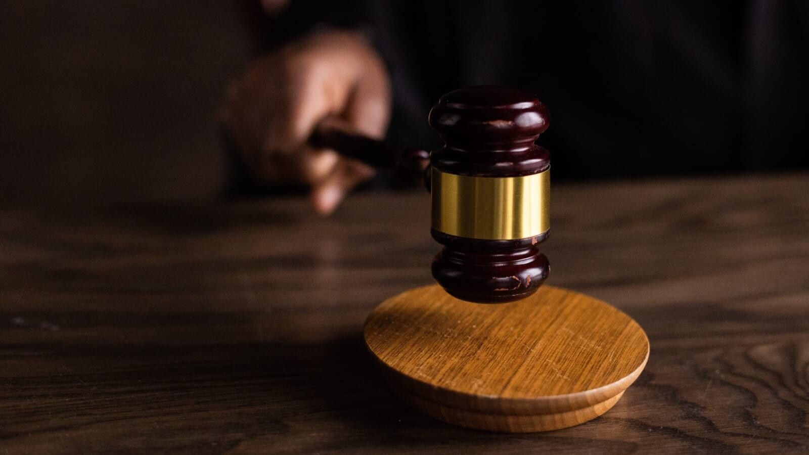 person banging a gavel on a wooden board