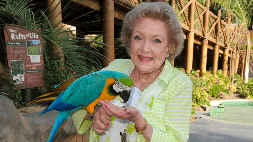 Betty White holding a parrot at the Los Angeles Zoo.