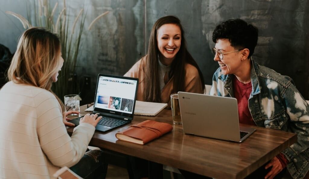 colleagues sit at table laughing