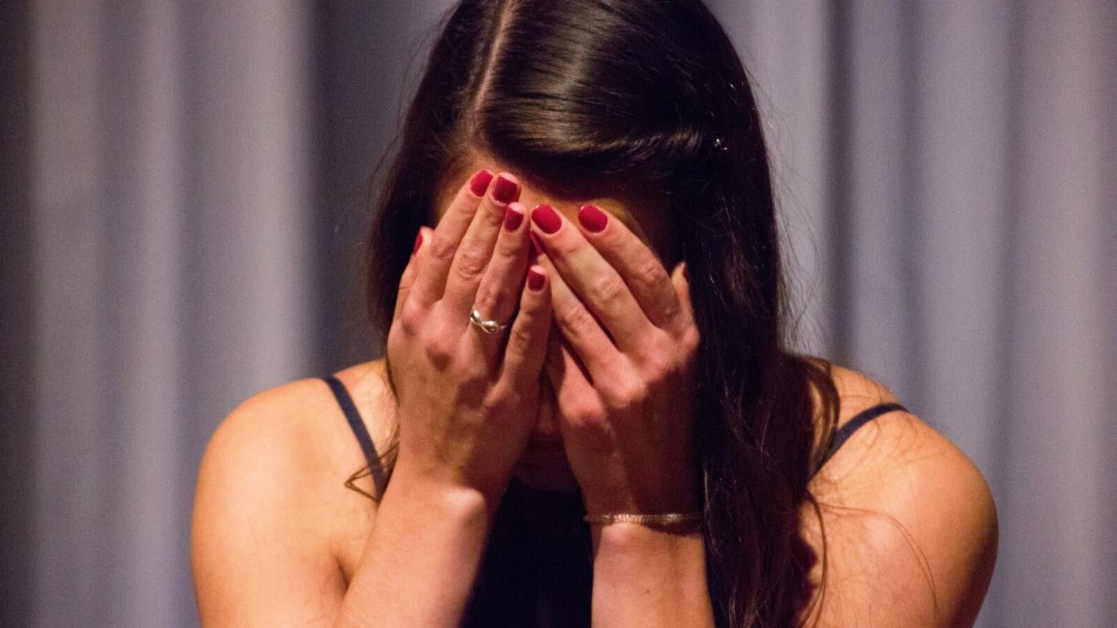 woman holding her head in her hands