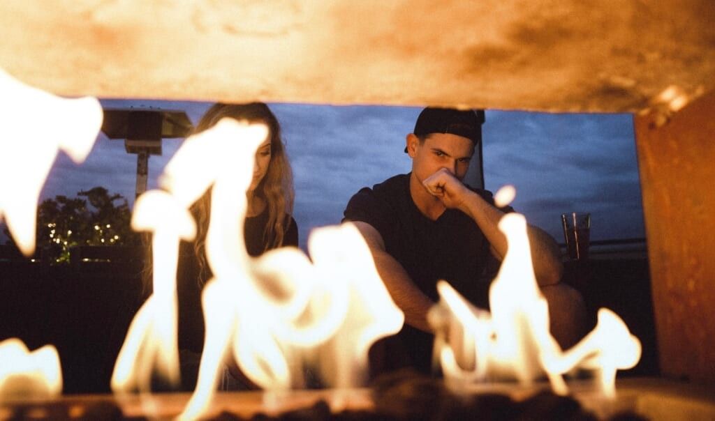 a couple sits in front of fire