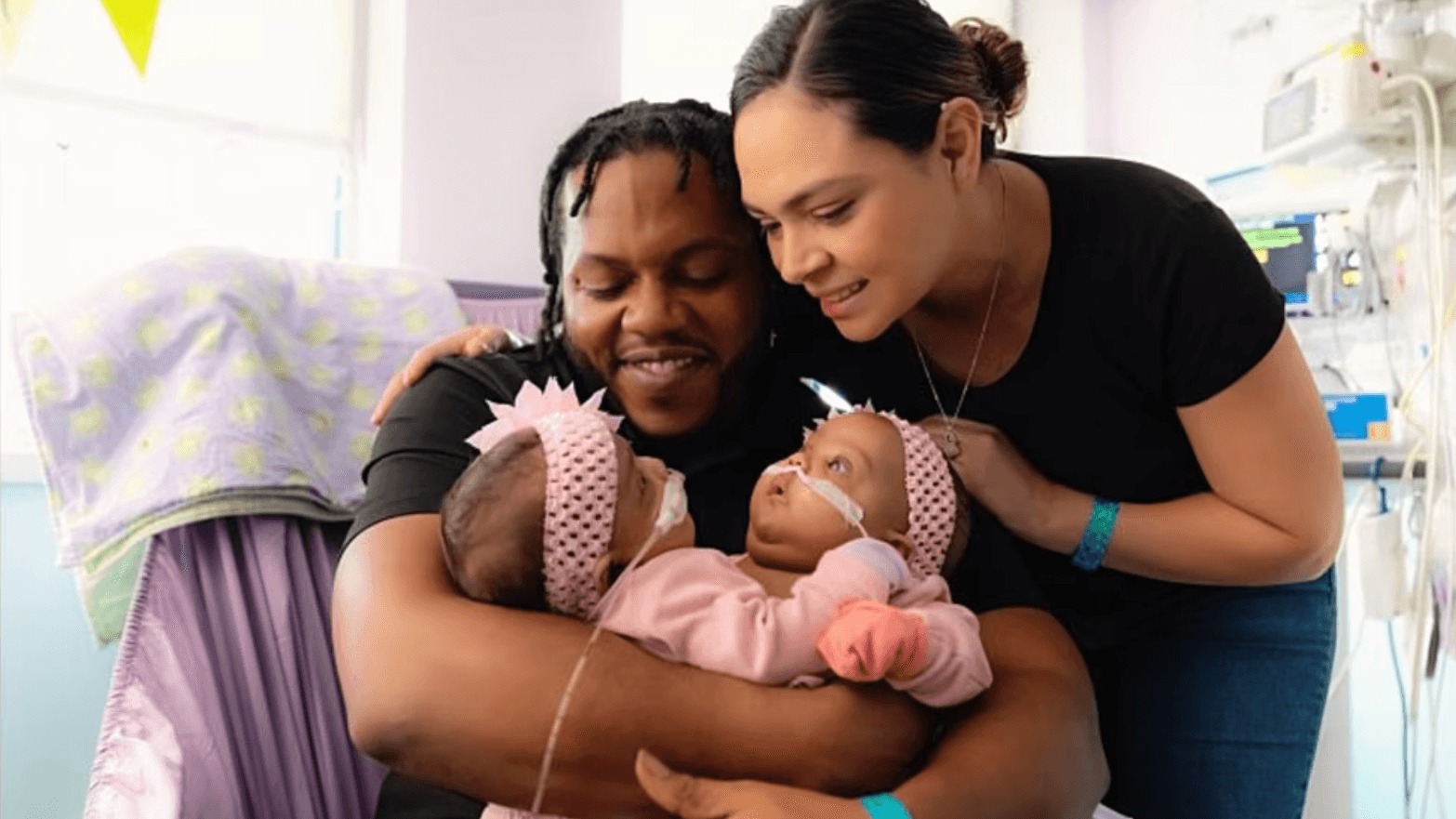 man and woman holding two baby girls in their arms