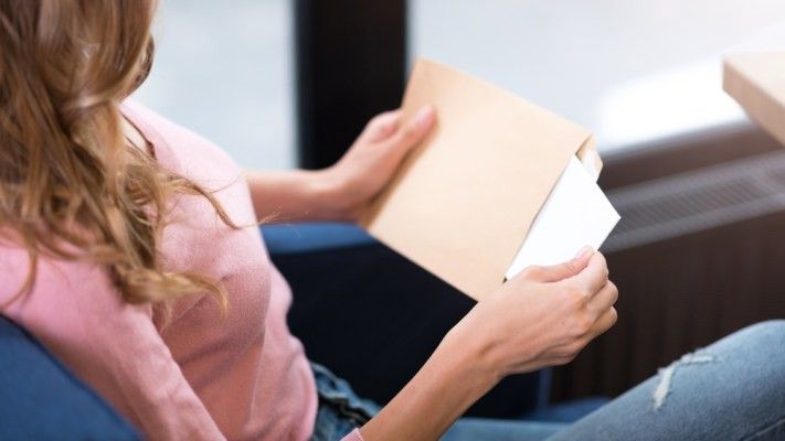Woman opening envelope