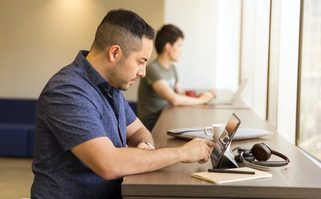 two adults learning on ipads at table