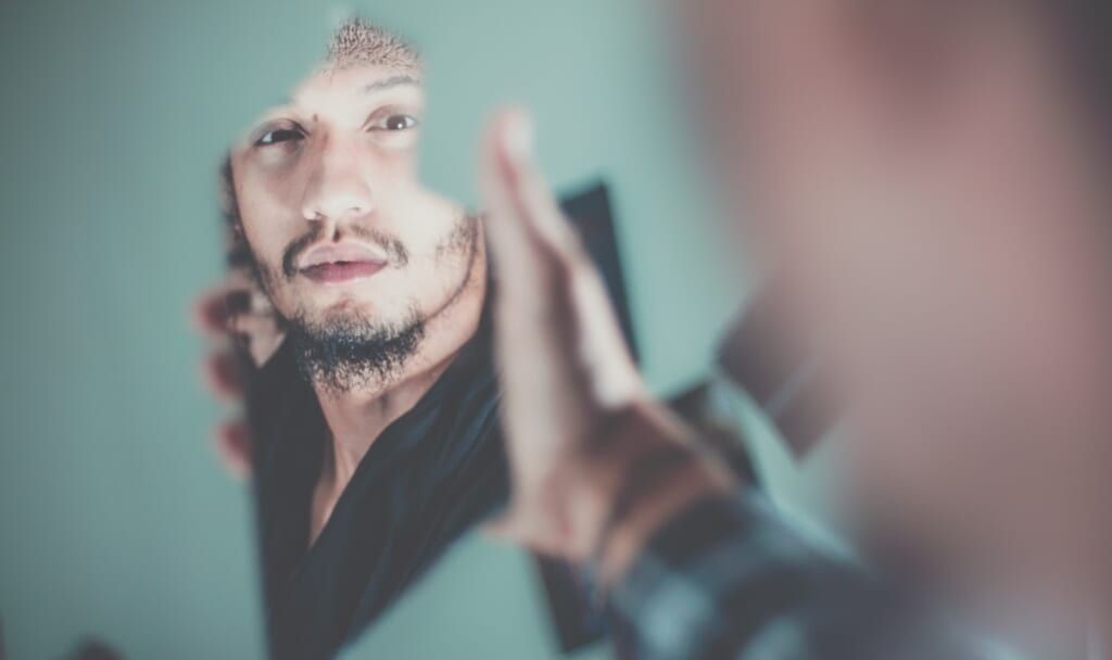 man looks at his reflection