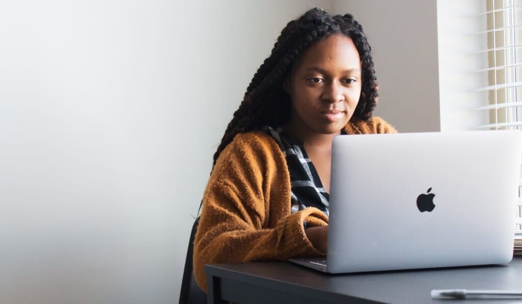 young woman writes on her laptop