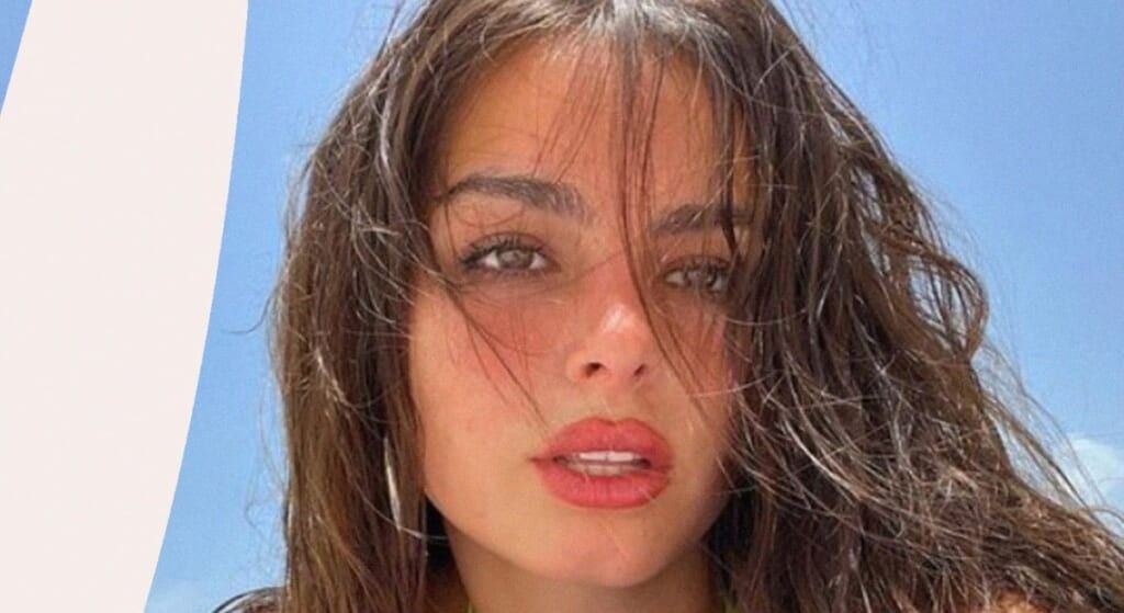 Addison Rae with dark hair and red lips.