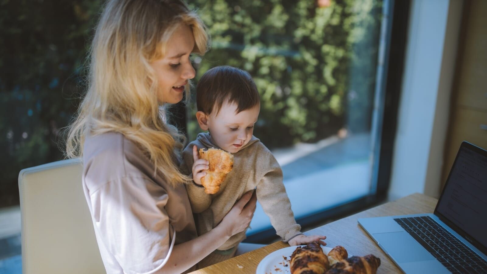 woman and her son eating croissants