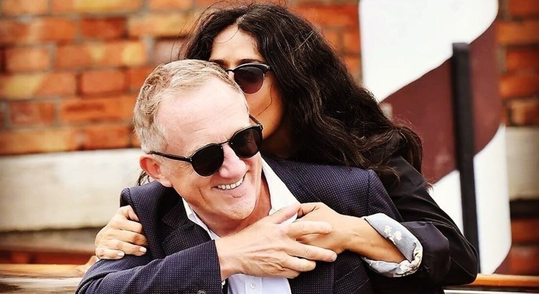 Actress Salma Hayek kissing husband Francois-Henri Pinault while they both laugh.