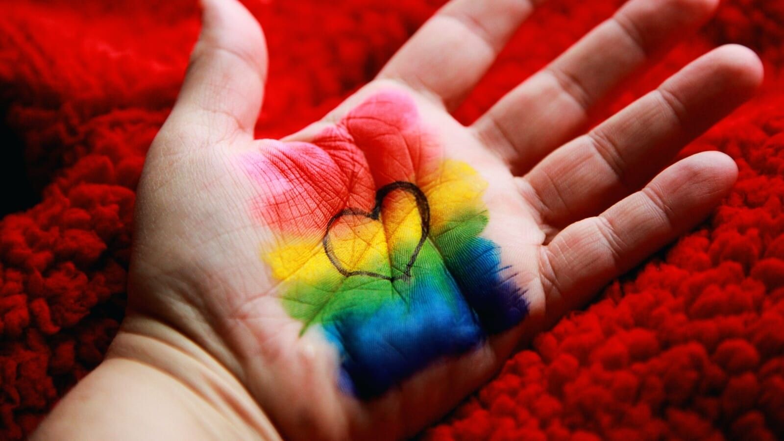 pride flag with a outline of a heart painted on a person