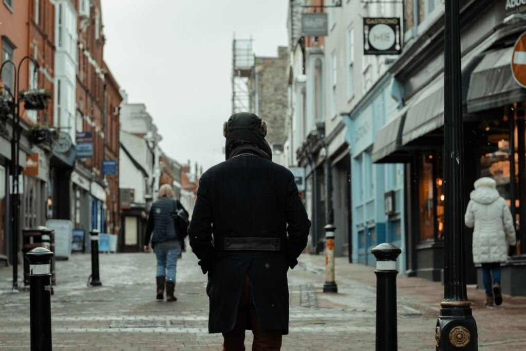 silhouette of a man standing on a busy road