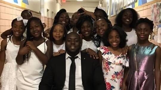 man with a bunch of kids standing around him