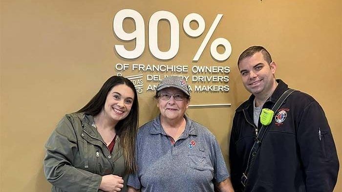 elderly woman standing with a man and a woman