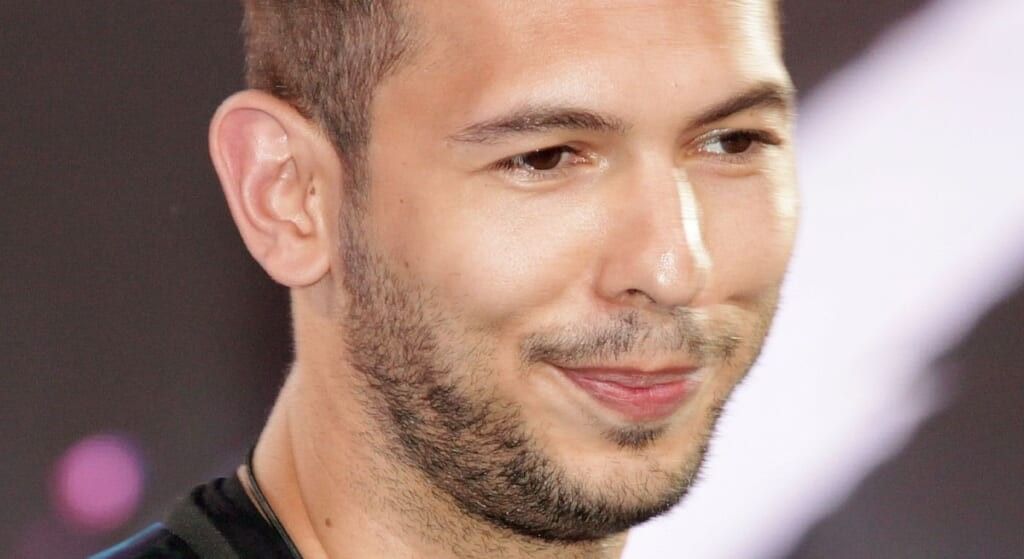 Andrew Tate smiling at the camera.