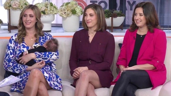 three women and a baby sitting on a couch