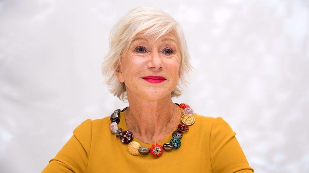 Helen Mirren smiling in yellow top