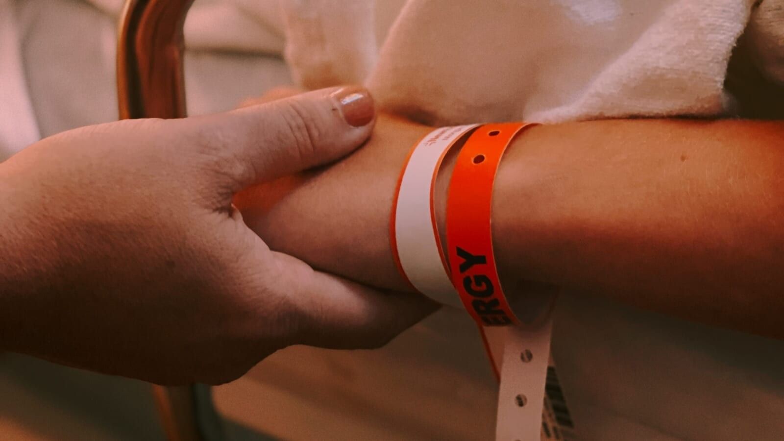2 people holding hands on a hospital bed
