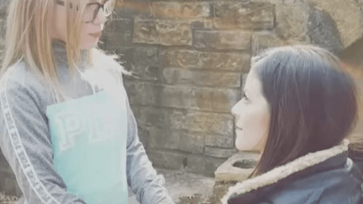 a woman kneeling in front of a little girl