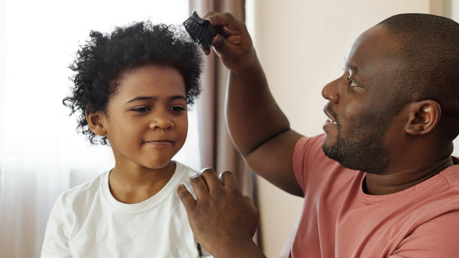 man combing little boy