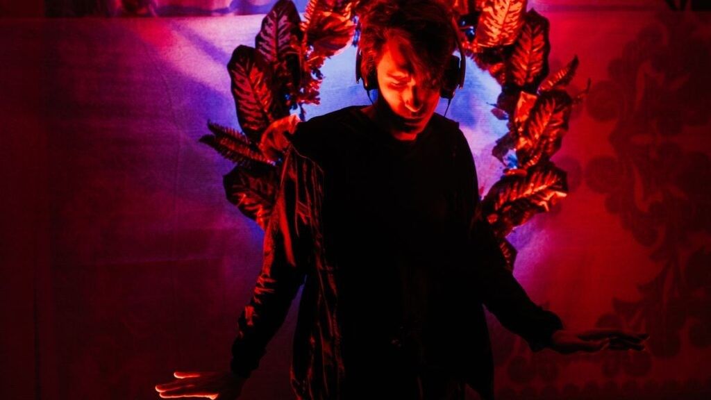 Man with headphones on red floral background