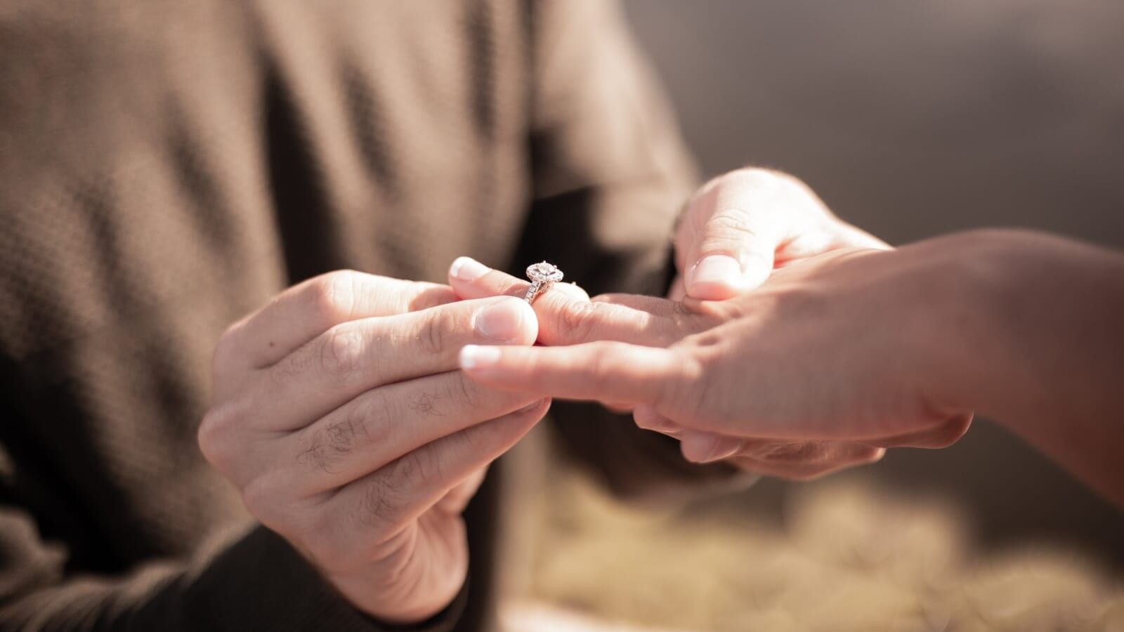 man putting a ring on a woman