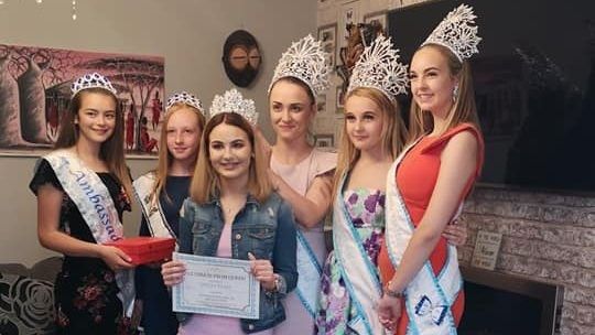 six girls wearing dresses and crowns
