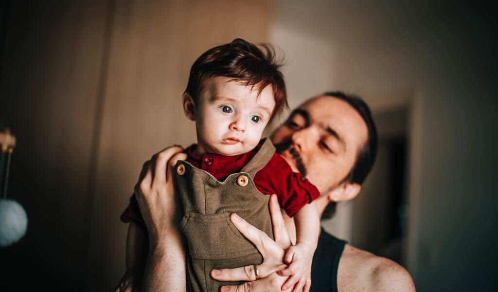 father and son pose inside their home