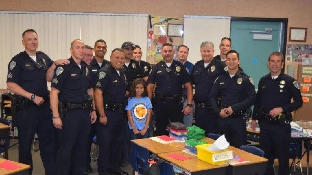 police officers and a little girl standing in a classroom