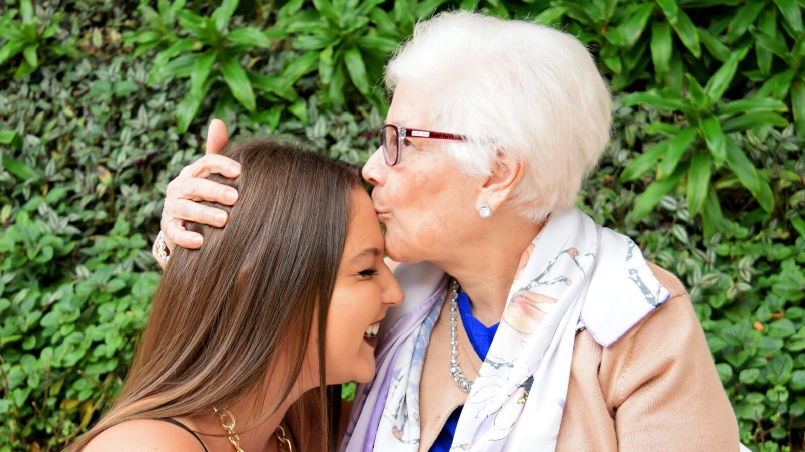 elderly woman kissing young woman