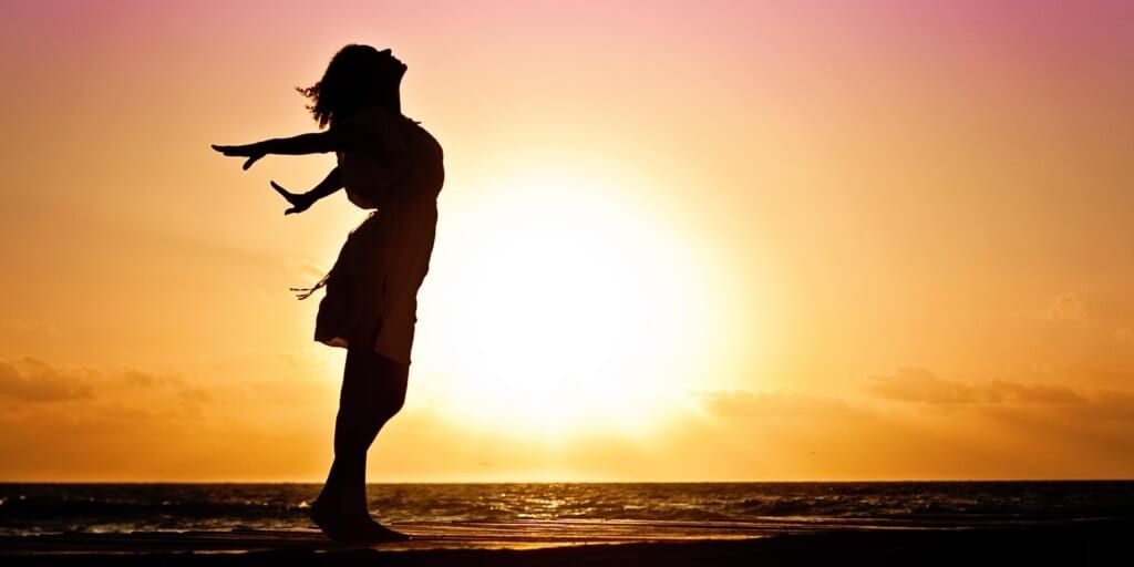 Silhouette of woman on beach at sunset by Jill Wellington on Pexels